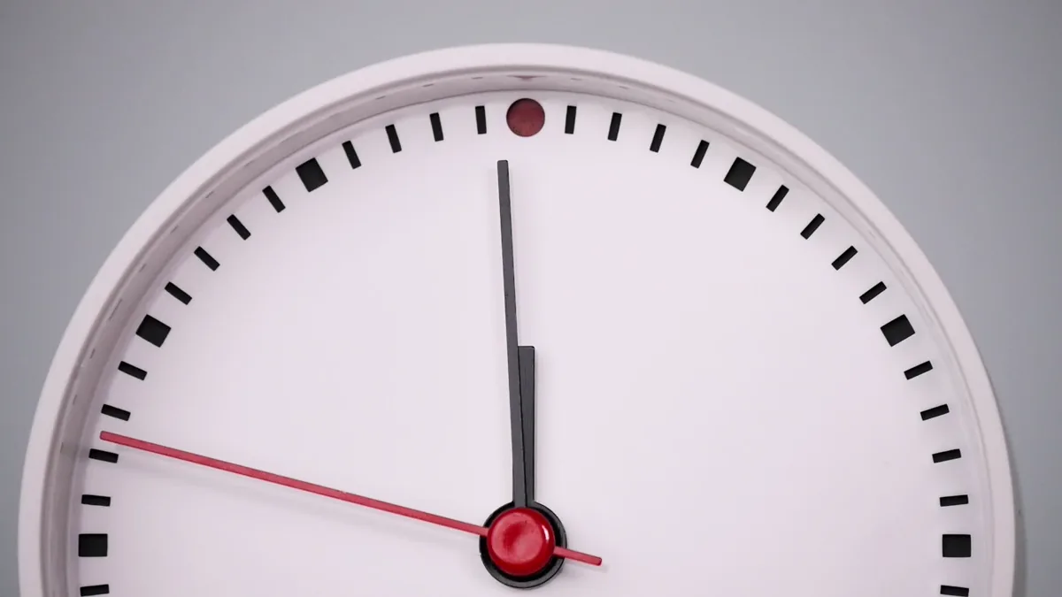 White wall clock showing midnight on a plain white background